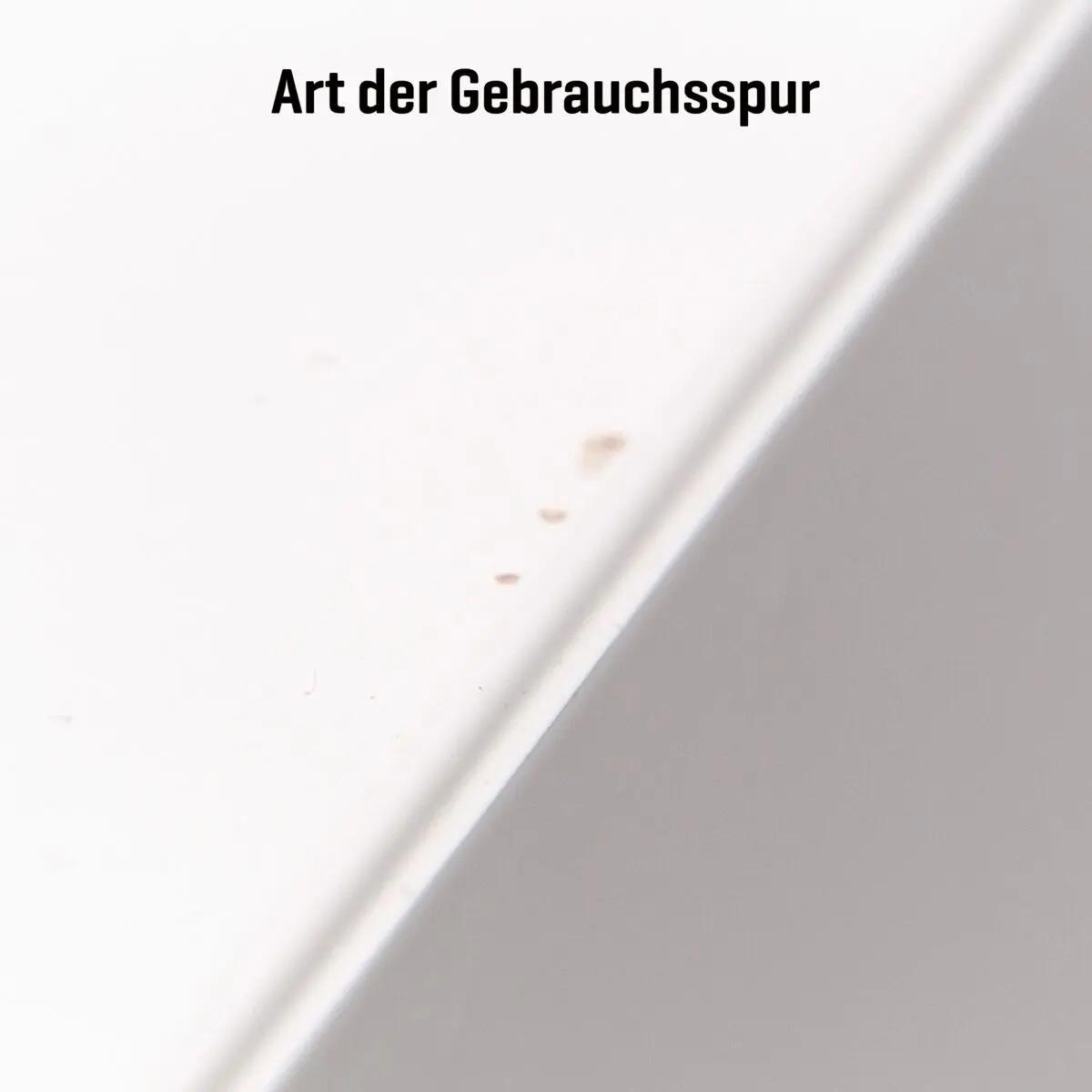 Weißer AED-Wandschrank (gebraucht) mit sichtbaren kleinen Gebrauchsspuren wie Schrammen und Verfärbungen auf der Oberfläche.