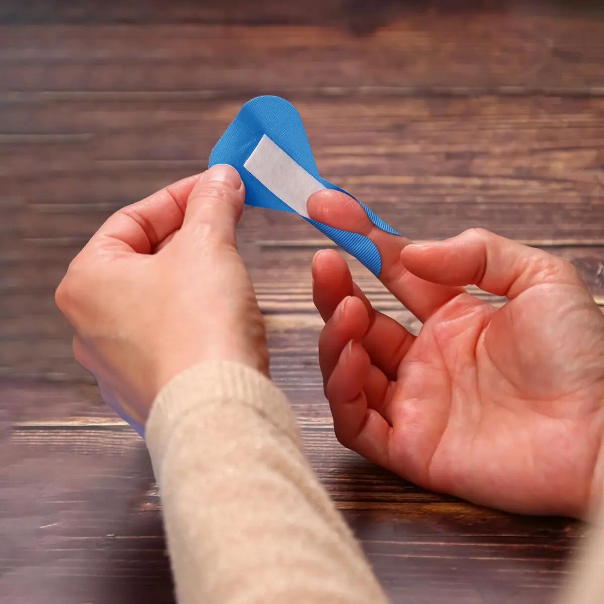 Eine Hand hält ein blaues Pflasterset Weroplast® AquaFlex Detect - Perfect Mix mit aluminiumbeschichteter Wundauflage und detektierbarer, wasserdichter Folie.