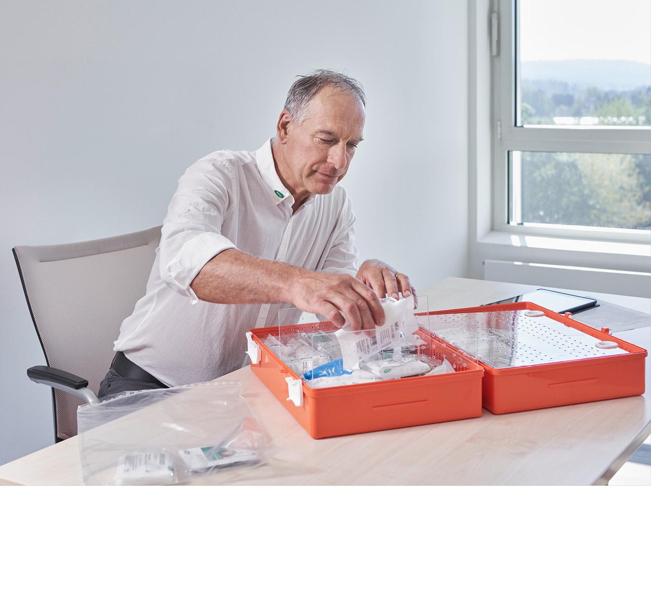 WERO Mitarbeitender räumt orangefarbenen Erste Hilfe Koffer ein 