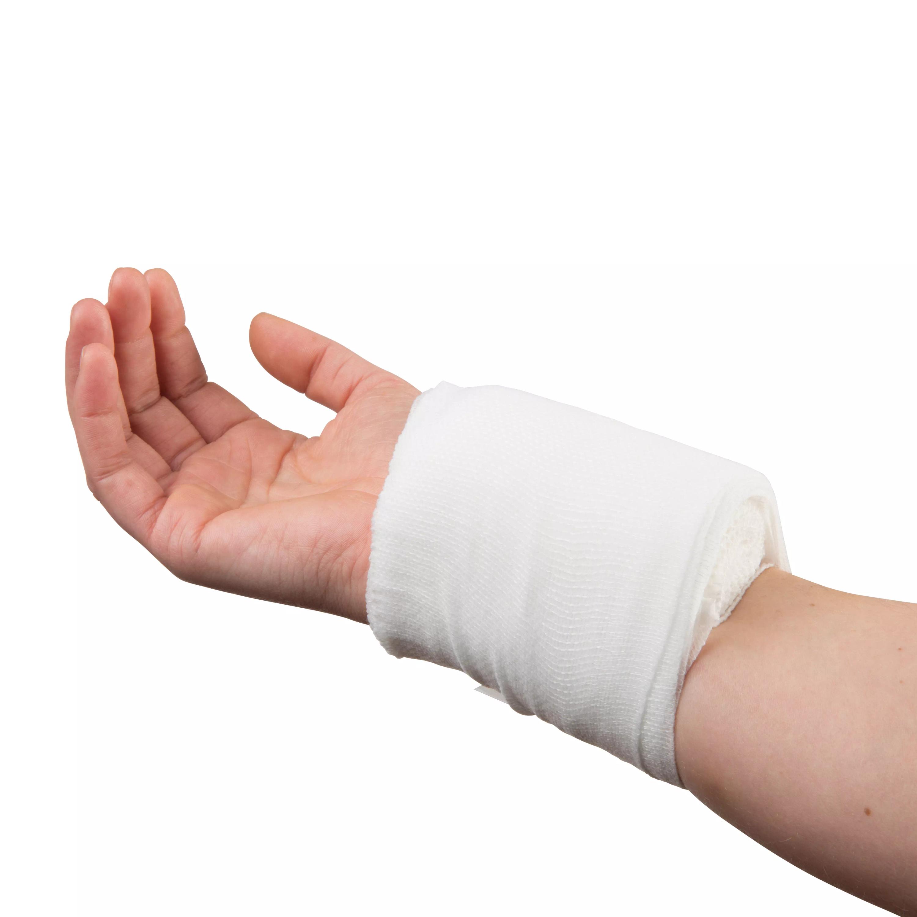 Ein WERO Druckverband, steril, liegt mit sichtbarem Druckpolster und elastischer Fixierbinde sicher um ein menschliches Handgelenk gewickelt.