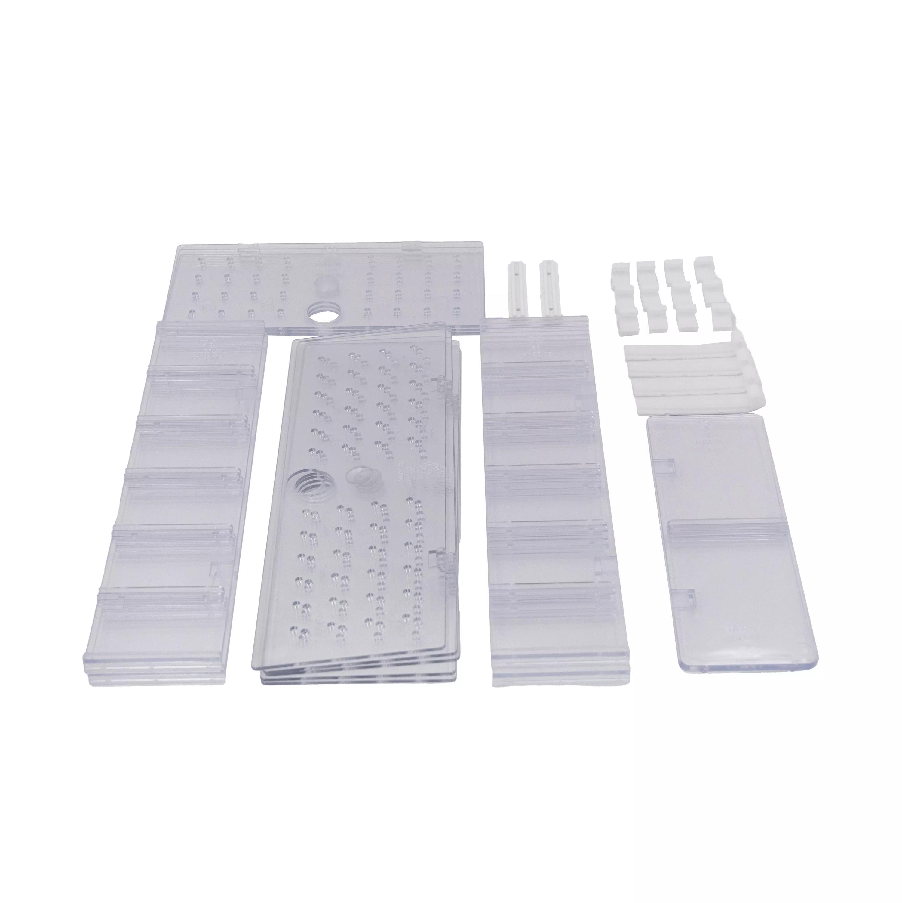 Mehrere transparente Kunststoffteile der Inneneinteilung für WERO Erste Hilfe Koffer – groß, darunter rechteckige Paneele, Trennwände und Adapter, liegen sortiert nebeneinander.