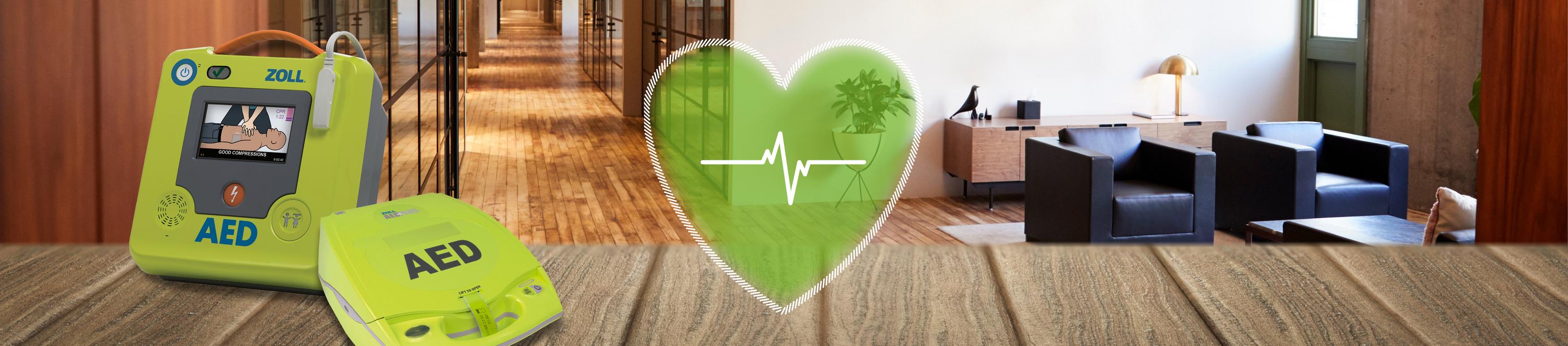 Zwei AED-Modelle auf einem Tisch. Daneben eine grafische Darstellung des Herzrythmus.