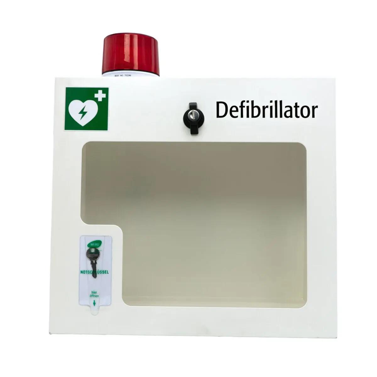 Weißer AED-Wandschrank (gebraucht) - mit Alarmfunktion, aus robustem Stahlblech, Sichtfenster und abschließbarem Drehverschluss, Defibrillator sichtbar.