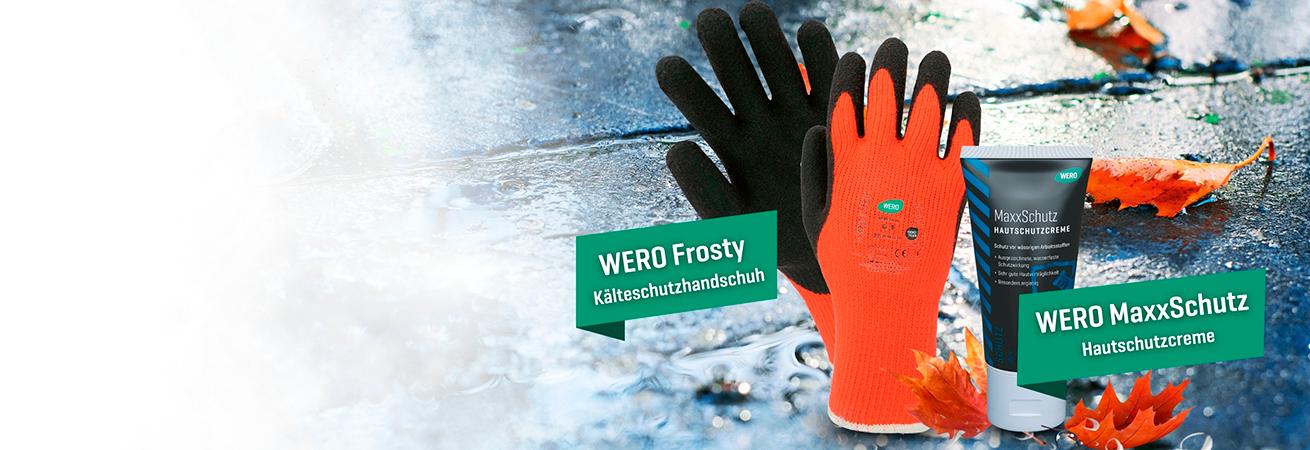 Zwei Paar WERO Frosty Kälteschutzhandschuhe in Schwarz und Orange neben einer Tube WERO MaxxSchutz Hautschutzcreme und orangefarbenen Blättern.