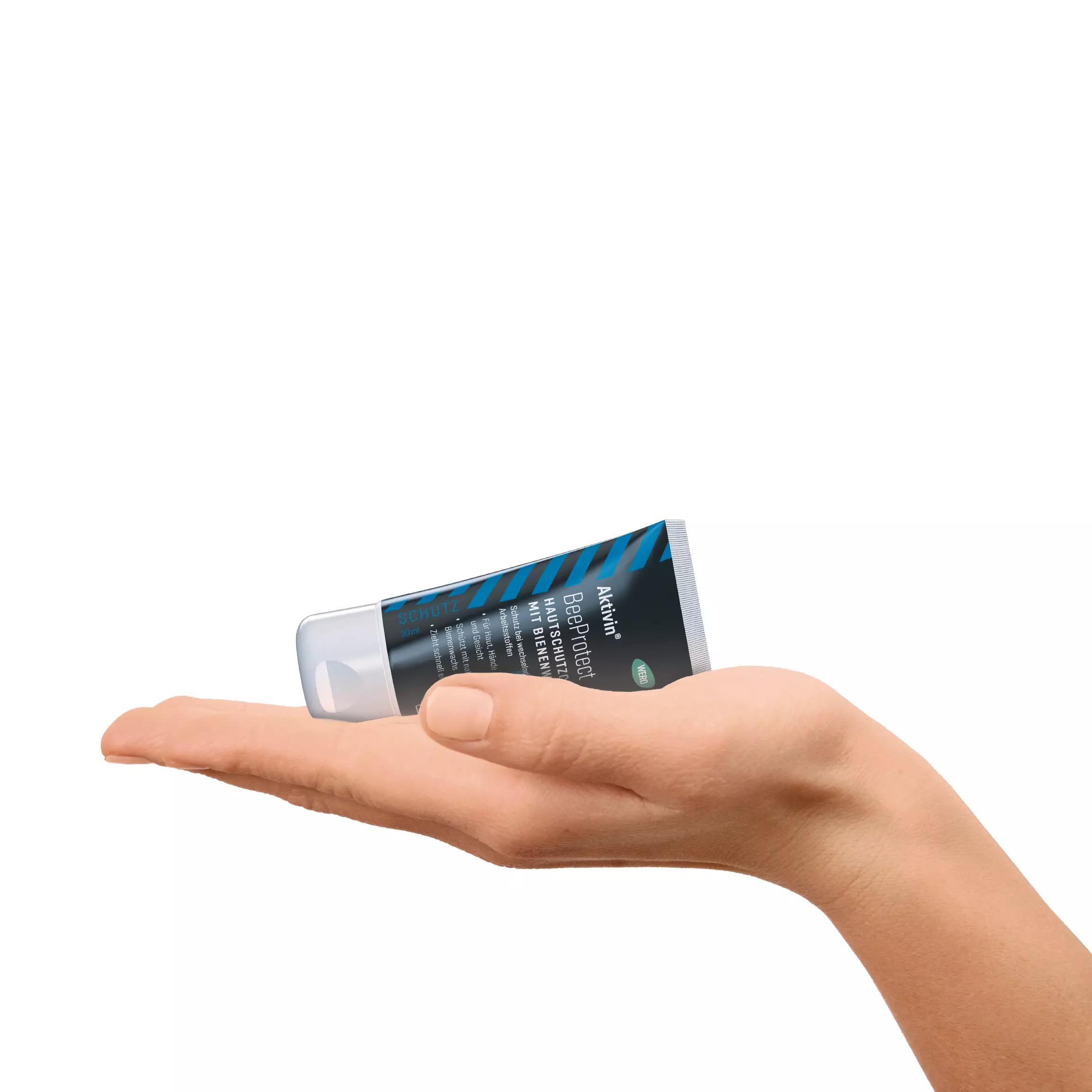 Eine Hand hält eine weiße Acvivin BeeProtect Tube mit blau-schwarzem Design und gut lesbarem Logo fest im Griff.