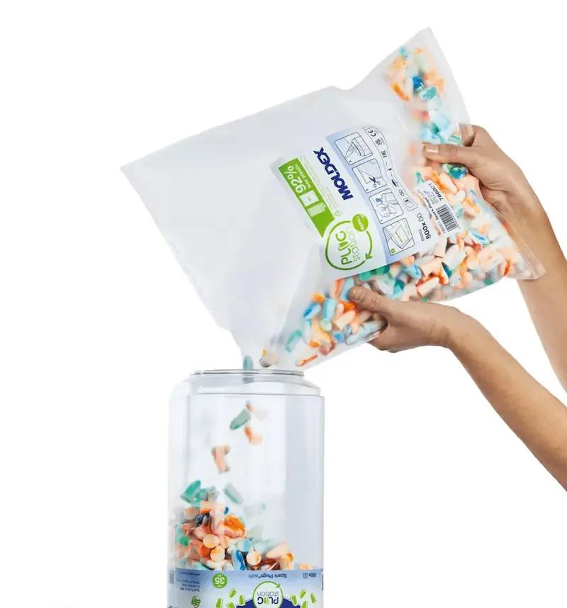 900 weiße Moldex PUc Sound Activ Ohrstöpsel mit bunten Akzenten werden aus Beutel in einen durchsichtigen Behälter mit Deckel gefüllt.