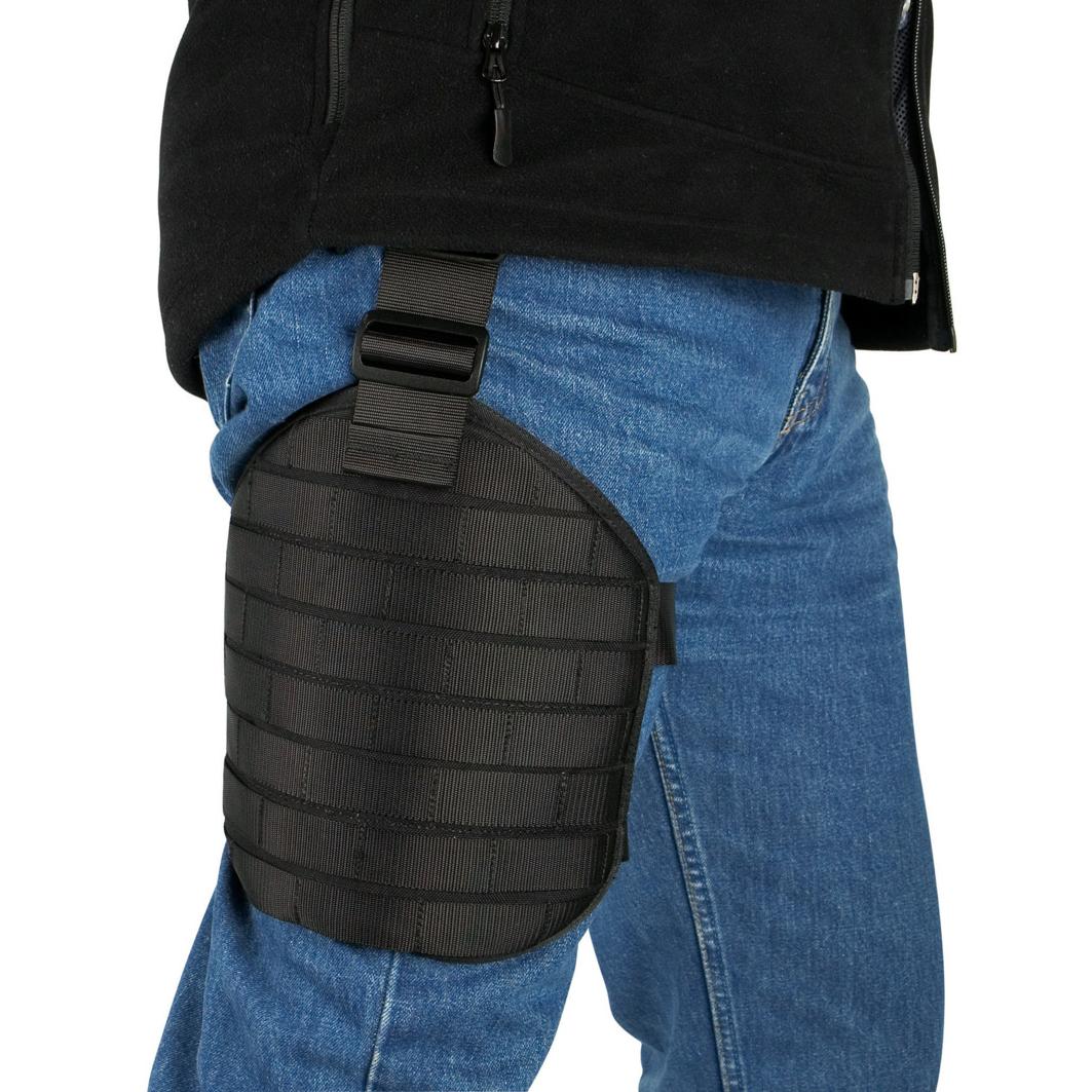 Die TT Leg Base - Schwarz ist als schwarze Beinplatte mit MOLLE-System am Bein befestigt und verfügt über mehrere rechteckige Verstärkungspaneele.