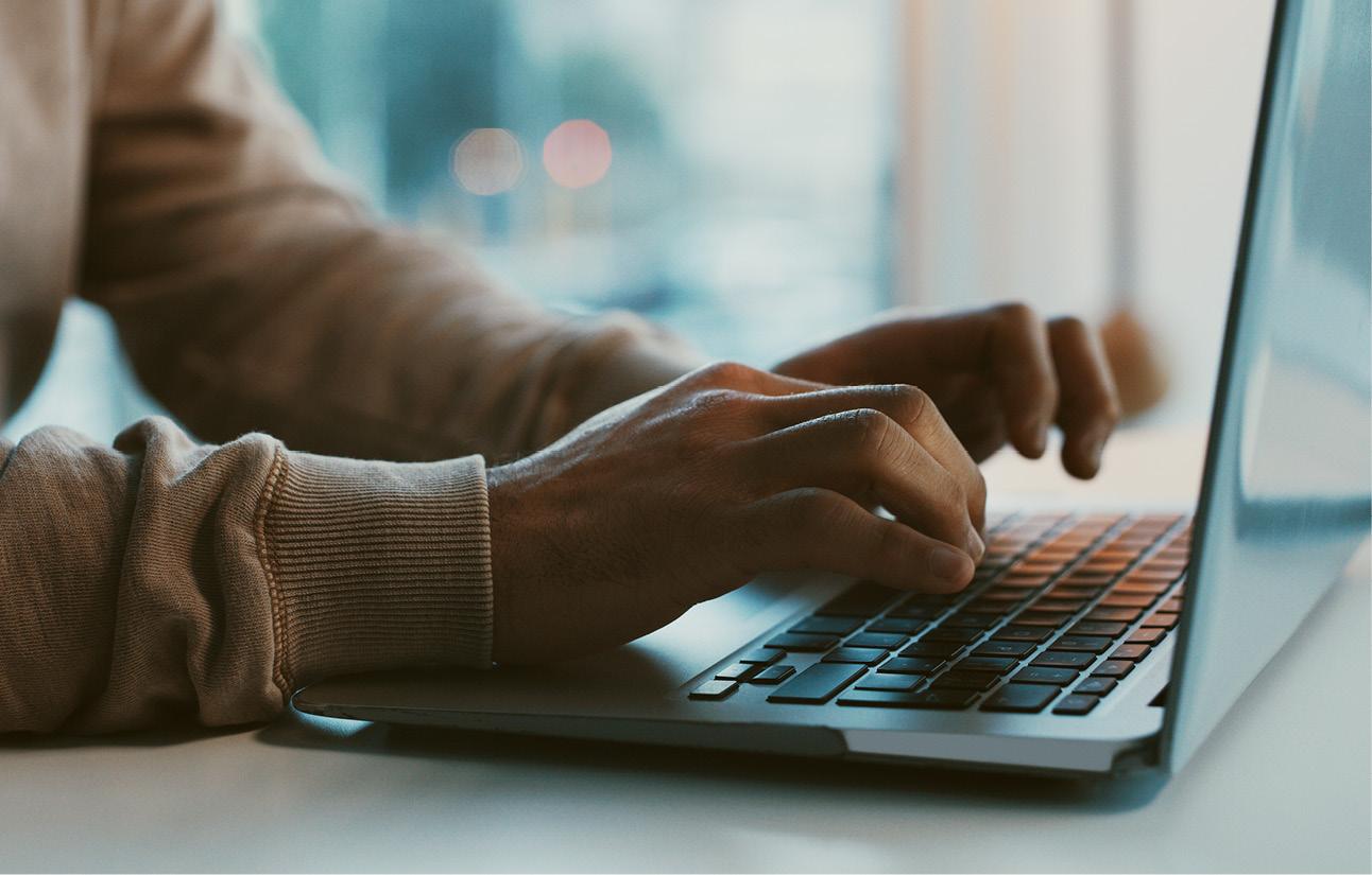 Zwei Hände tippen auf einer Laptop-Tastatur.