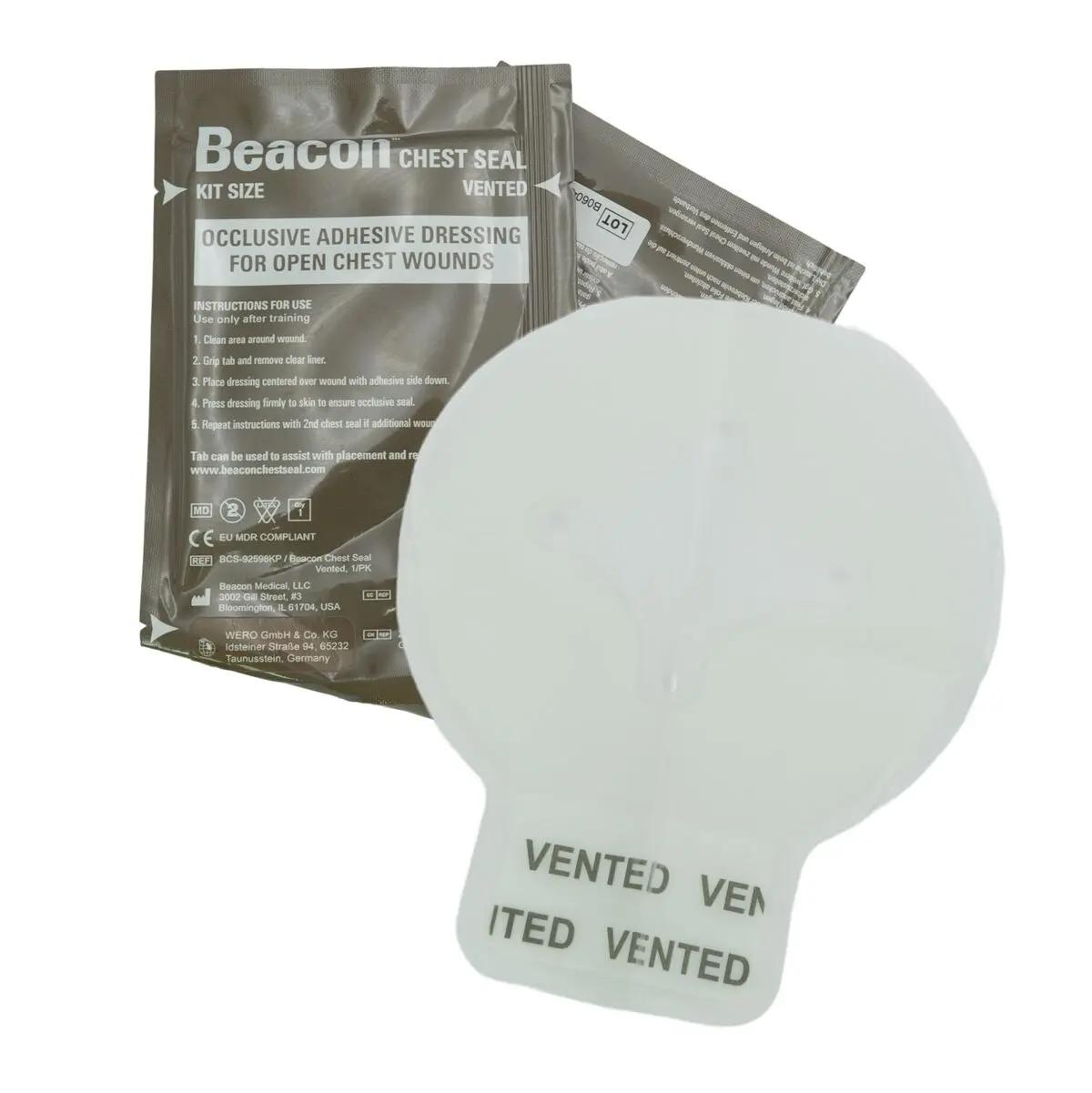 Ein weißes Beacon™ Chest Seal - vented mit vier Entlüftungskanälen liegt auf einer braunen Verpackung mit Hinweistexten und Anleitung.