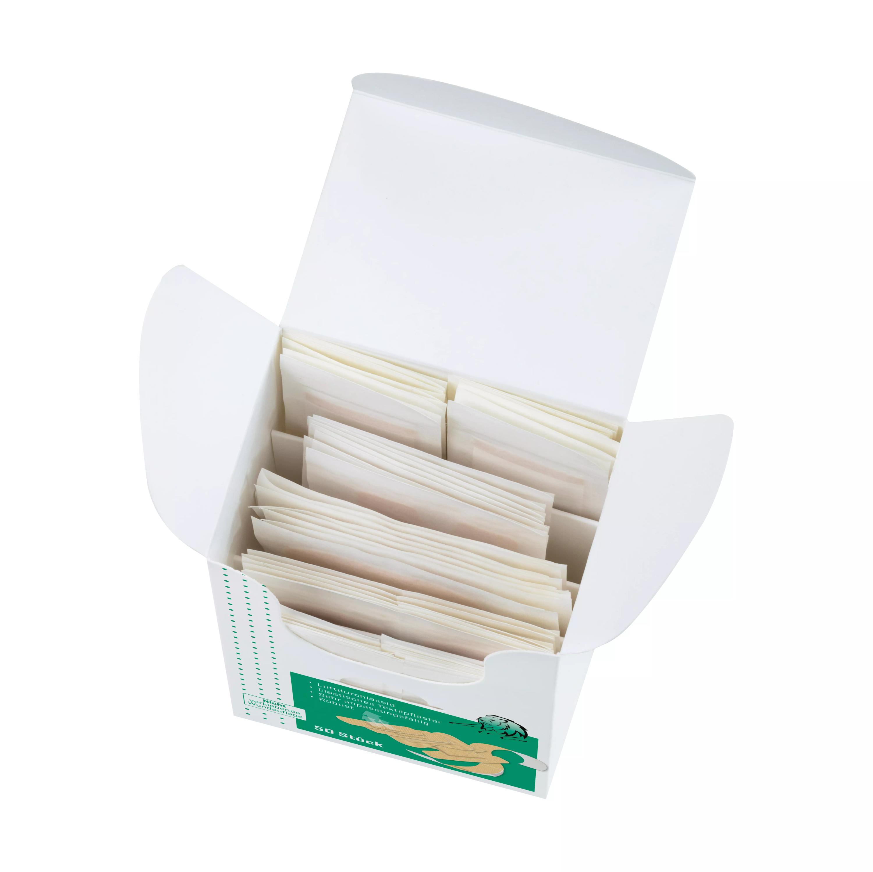 Eine geöffnete Box Pflasterset Weroplast® MasterTex - Perfect Mix zeigt ordentlich gestapelte, rechteckige, cremefarbene Pflasterpackungen mit grünem Etikett.