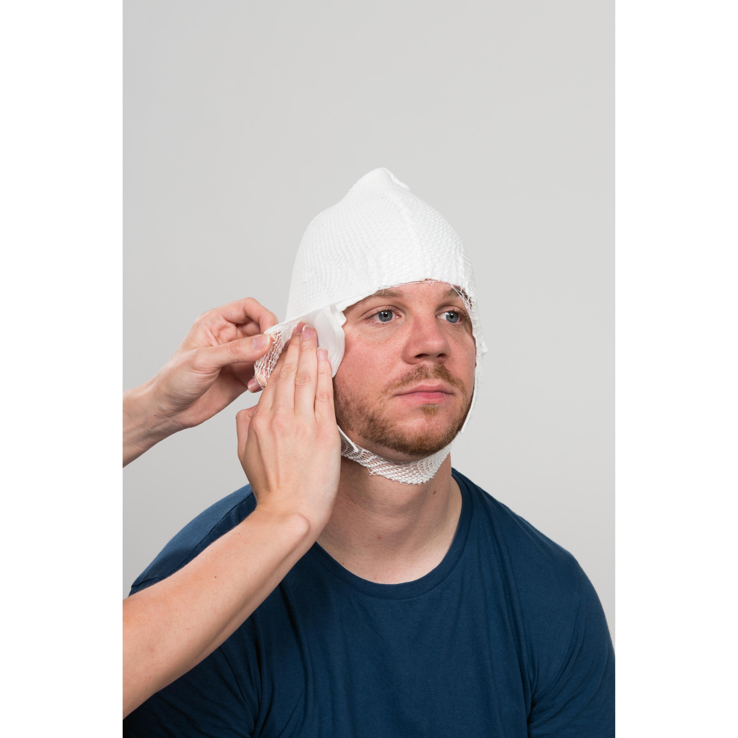 Ein Mann trägt einen WERO MediCap Kopfschnellverband, dessen weiße Wundauflagen-Haube mit integriertem Netzverband kopfumschließend sitzt.