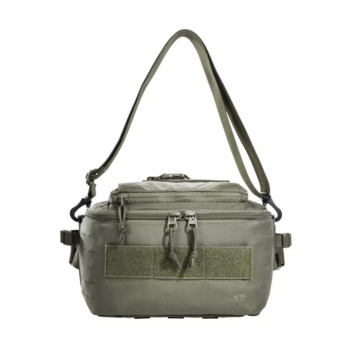 Eine grüne TT Medic Hip Bag IRR aus robustem CORDURA® mit Reißverschluss-Frontfach, mehrfachen Gurten und abnehmbarem Schultergurt steht aufrecht.