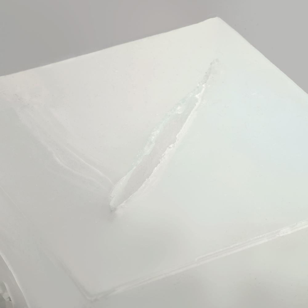 Eine weiße, glatte Oberfläche des Wound Cube™ zeigt eine diagonale sowie eine kleinere Rissbildung, die an Glas erinnern.
