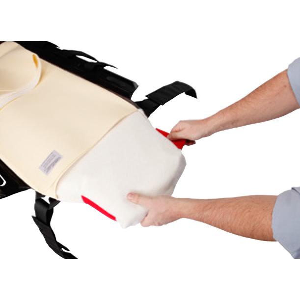 Zwei Hände halten ein teilweise geöffnetes CM Trauma Mattress™ Cover mit T-Fix™, das weiße Material, schwarzen Riemen und roten Sicherheitsverschluss zeigt.