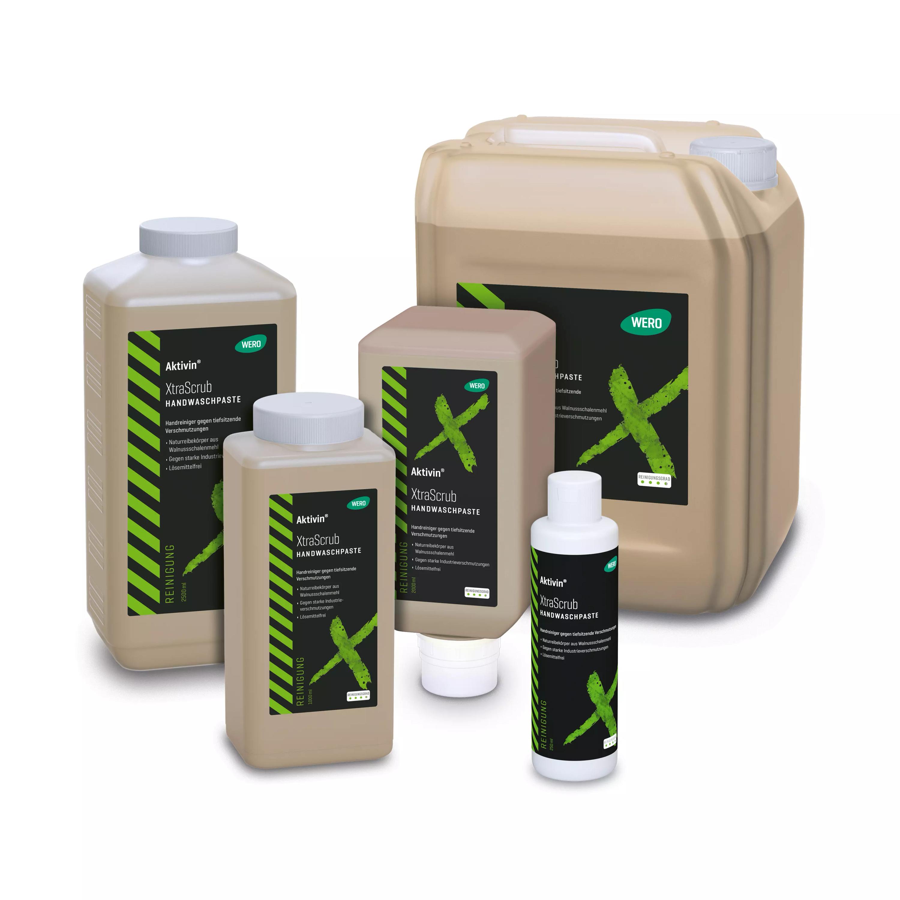 Fünf unterschiedlich große Flaschen Hautreinigung Aktivin® XtraScrub mit grün-schwarzem Design und Walnussschalenmehl-Formulierung stehen gruppiert auf weißem Untergrund.