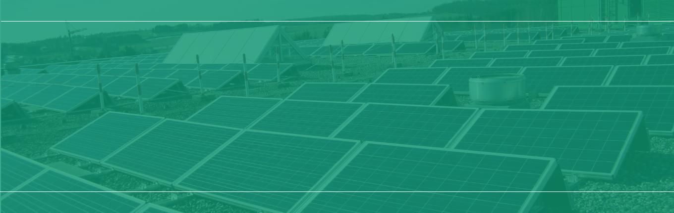 Solarmodule in Reihen aufgestellt, montiert auf Metallgestellen auf Kiesboden, mit Zelt und Gebäudeteil im Hintergrund, grün beleuchtet.