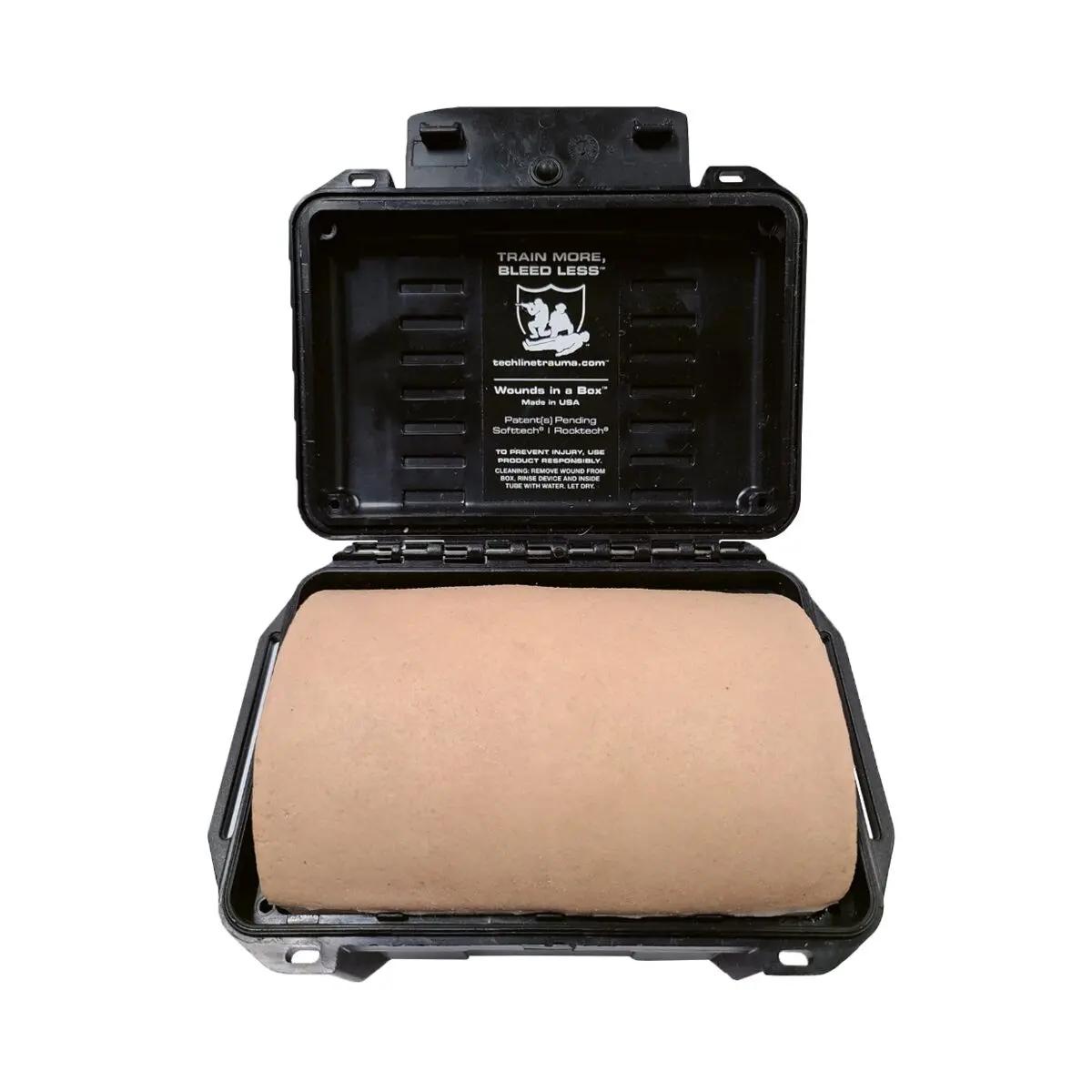 Ein geöffneter Techline Zugangstrainer Wounds in a Box® Serie mit beigem, realistisch wirkendem Hautmodell und Trainingsaufschrift.