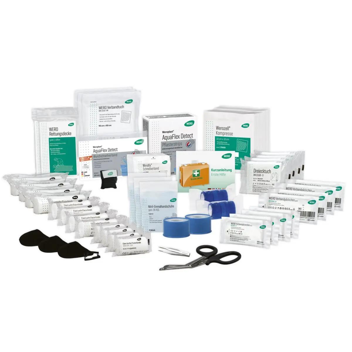 Mehrere medizinische Produkte aus der WERO Basis Füllung ÖNORM Z 1020, Typ 2 detektierbar, sorgfältig sortiert mit weißen und grünen Verpackungen, Schere und Verbandsmaterial.