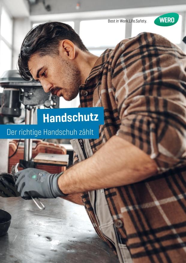 Ein Mann im Karohemd trägt Arbeitshandschuhe und arbeitet konzentriert mit Werkzeug an einer Maschine in einer Werkstatt.