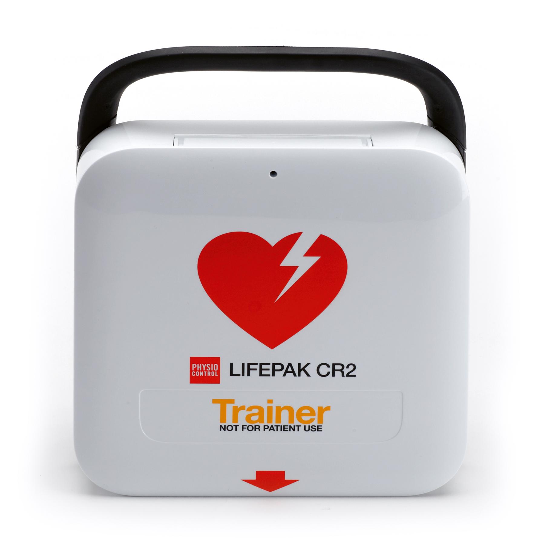 Trainingsgerät LIFEPAK CR2 mit schwarzem Griff, rotem Herzsymbol mit Blitz, gelber Aufschrift "Trainer" und Markierung "NOT FOR PATIENT USE" auf der Vorderseite.