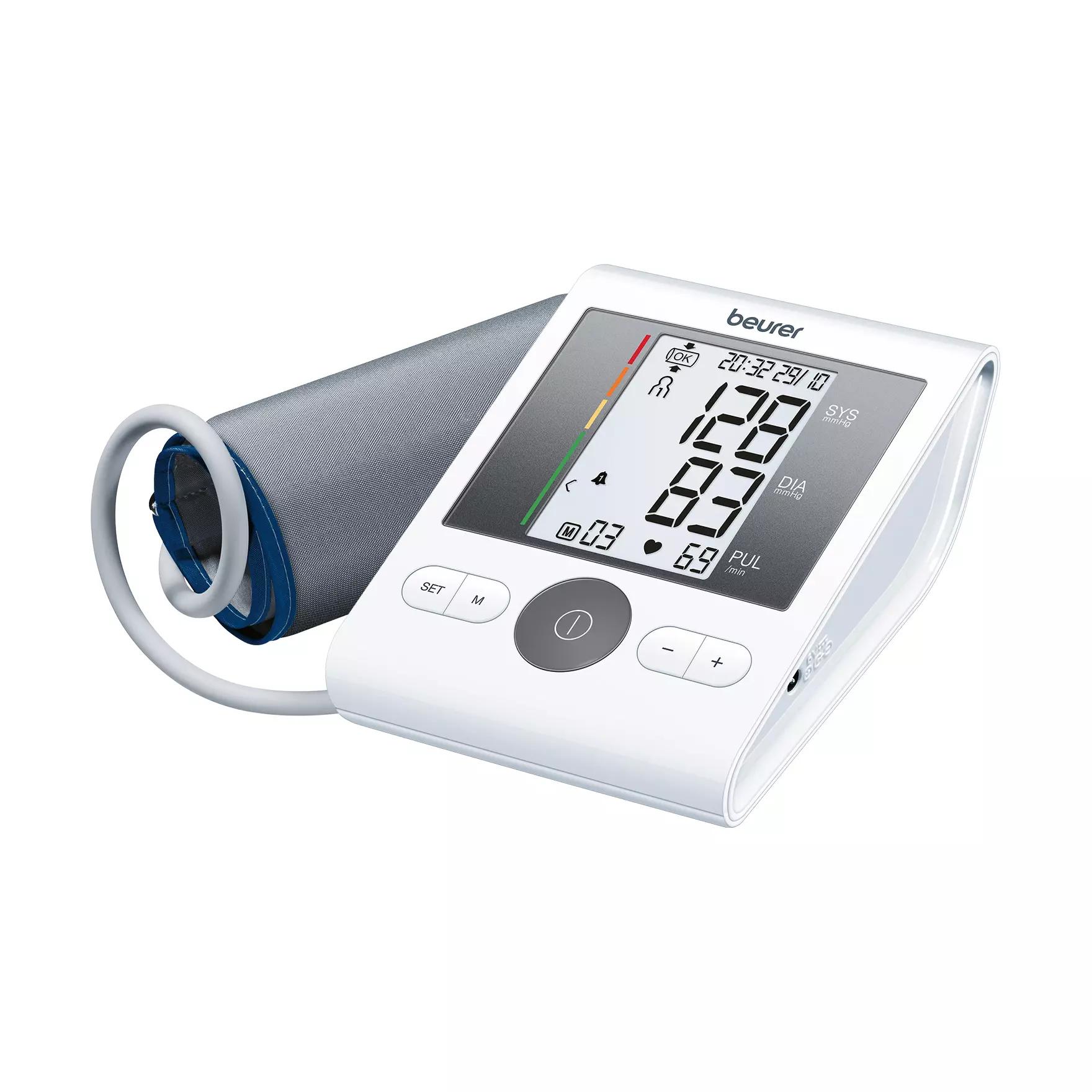 Digitales Beurer Blutdruckmessgerät mit grauer Manschette, beleuchtetem Display und Messwerten von 120/83 sowie Bedienknöpfen auf der Vorderseite.