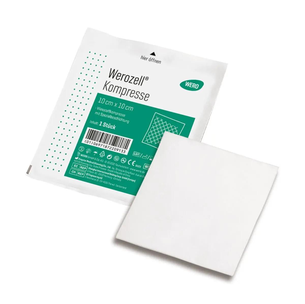 Sterile Werozell® Kompresse, 10 x 10 cm, aus weißem Vlies mit spezieller Beschichtung, teils aus der Verpackung gezogen, grün etikettiert.