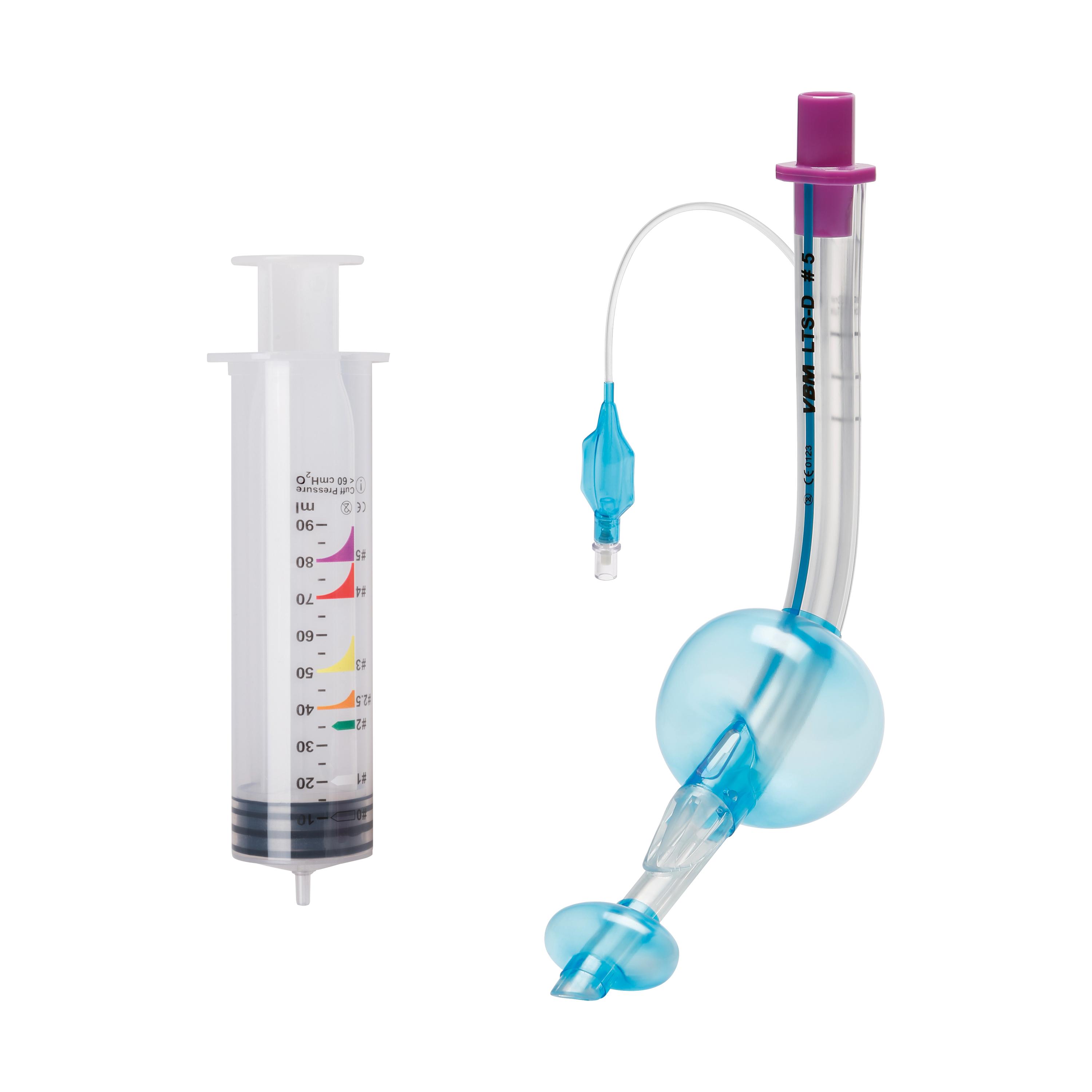 Eine unbenutzte Spritze mit klarer Kanüle und lila Kolben, daneben ein blauer Schlauch mit runder Pumpe und Etikett "VBM LTS D-5".