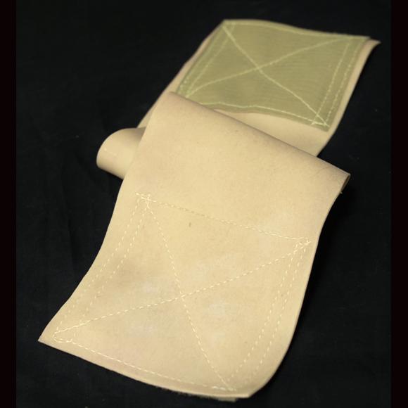 Gefaltete Techline Moulage Verlängerung aus beigefarbenem Stoff mit weißer Ziernaht, strukturiert und quadratisch geformt.