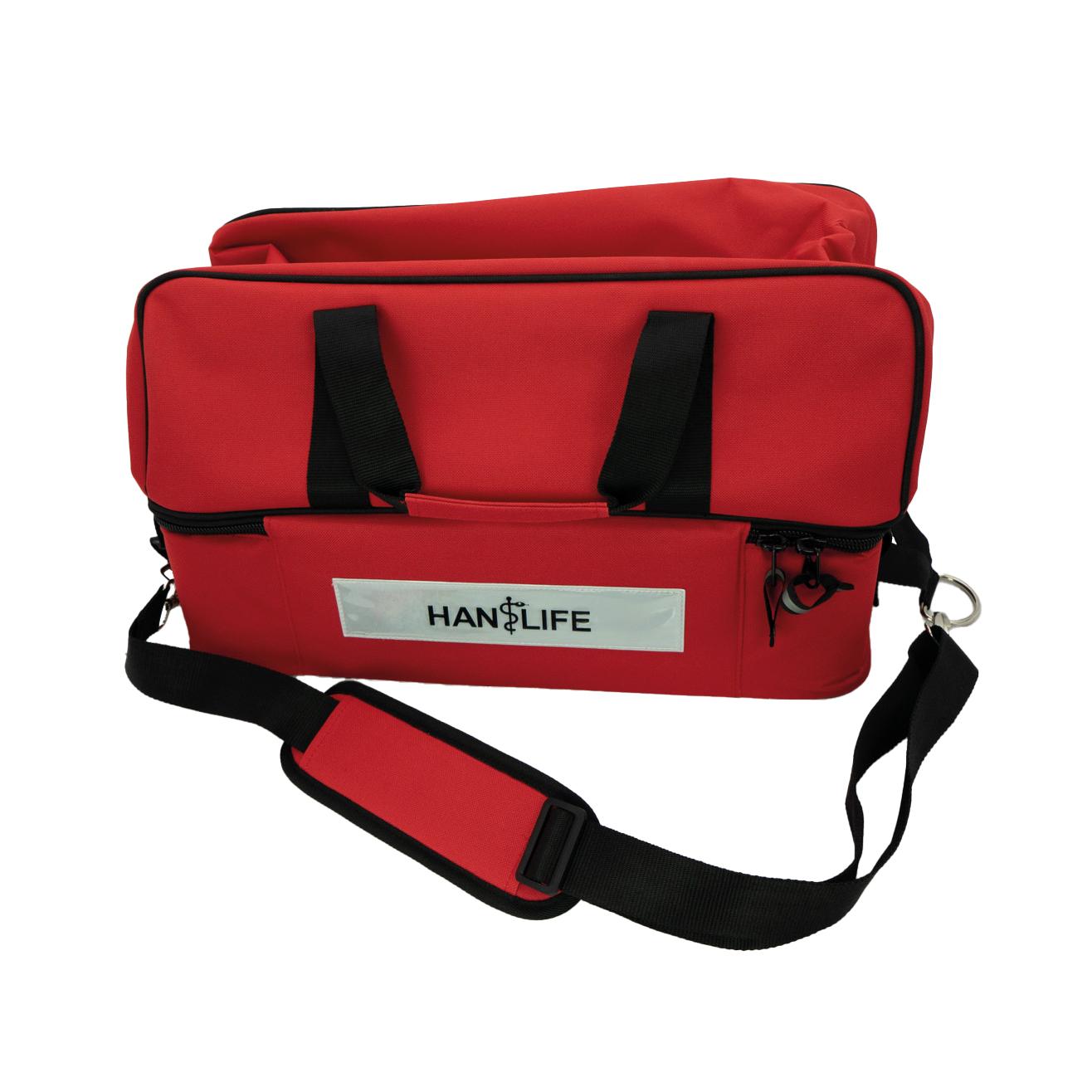 HAN-LIFE Notfalltasche, leer, steht aufrecht mit schwarzen Tragegriffen, Schultergurt und Frontfach aus wasserabweisendem, robustem Material.