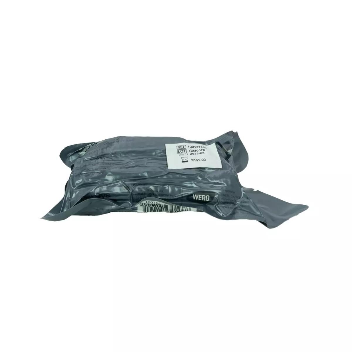 Schwarze, rechteckige, versiegelte Verpackung der Die Emergency Bandage®, das ORIGINAL - Oliv, 10 cm mit Barcode und weißem Etikett auf der Oberseite.