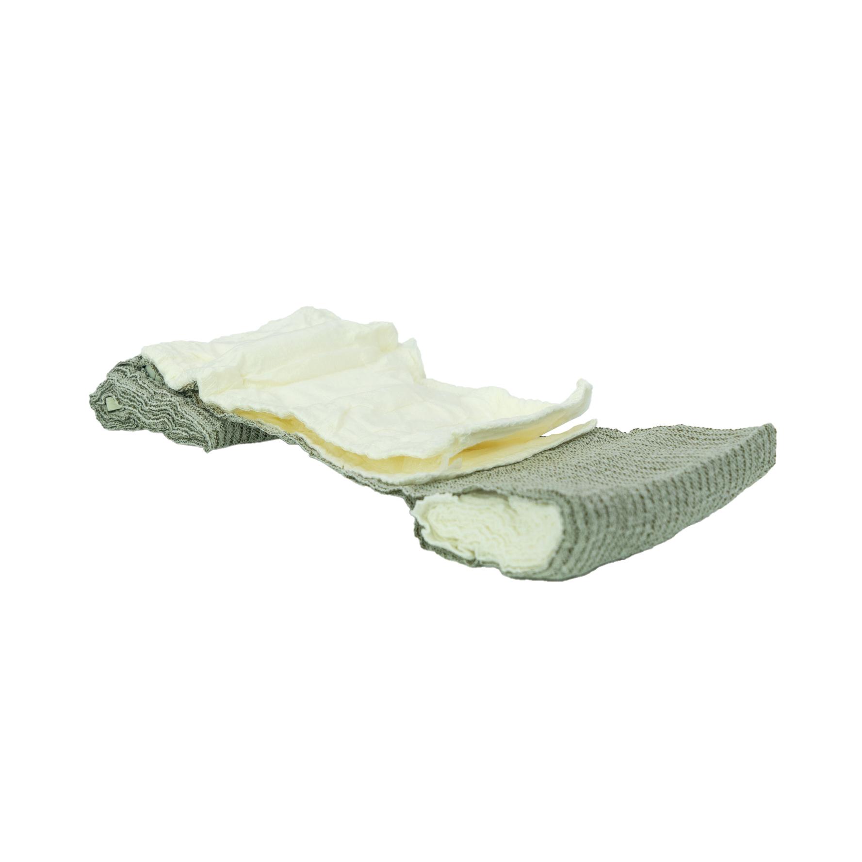 Die T3 Bandage™ ist halb entrollt zu sehen, zeigt ihre cremige, weiche Innenseite und die graue, strukturierte Außenseite sowie ihren lagenweisen Aufbau.