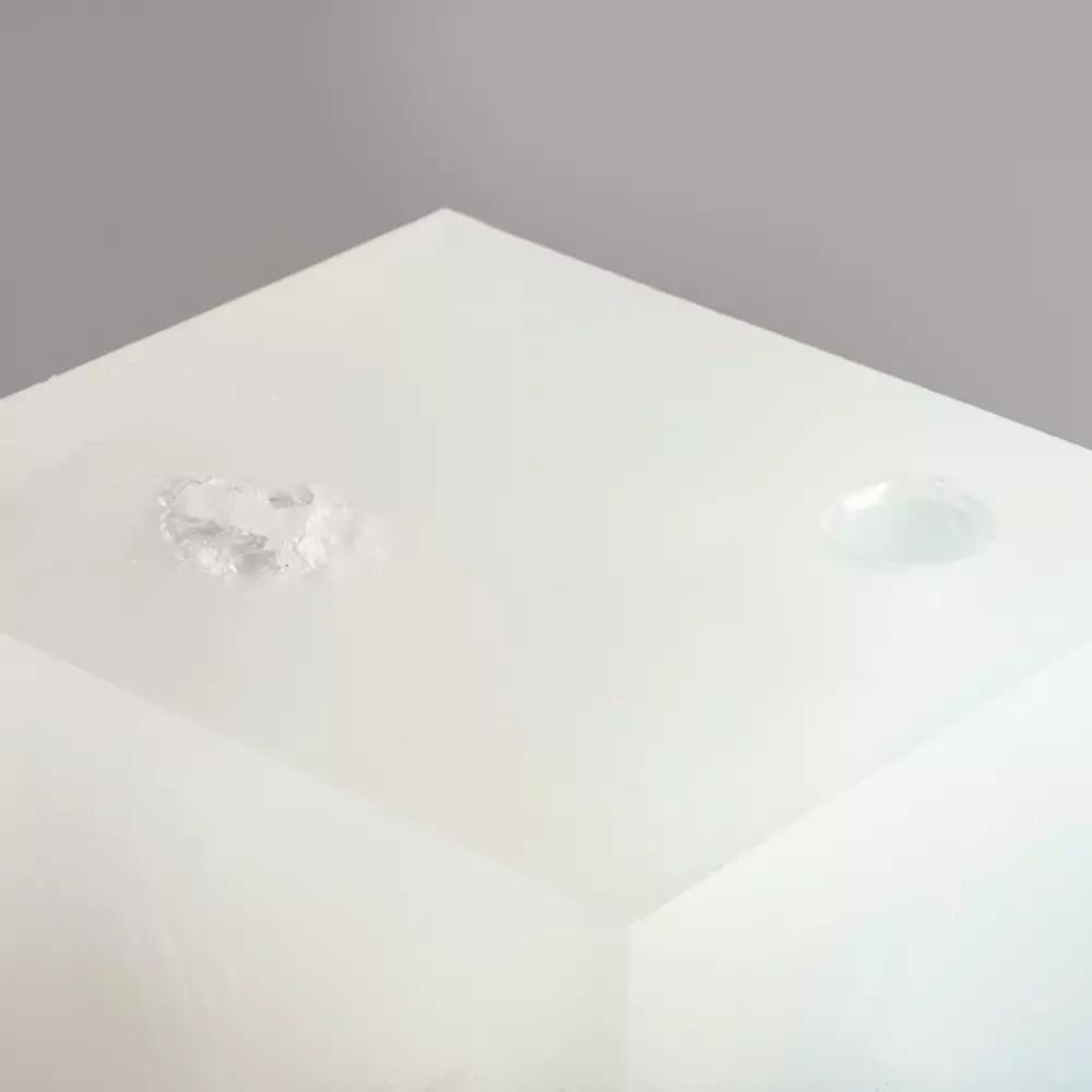 Ein weißer, quaderförmiger Wound Cube™ mit glatter Oberfläche und zwei Löchern, geeignet zum Üben der Blutungskontrolle.