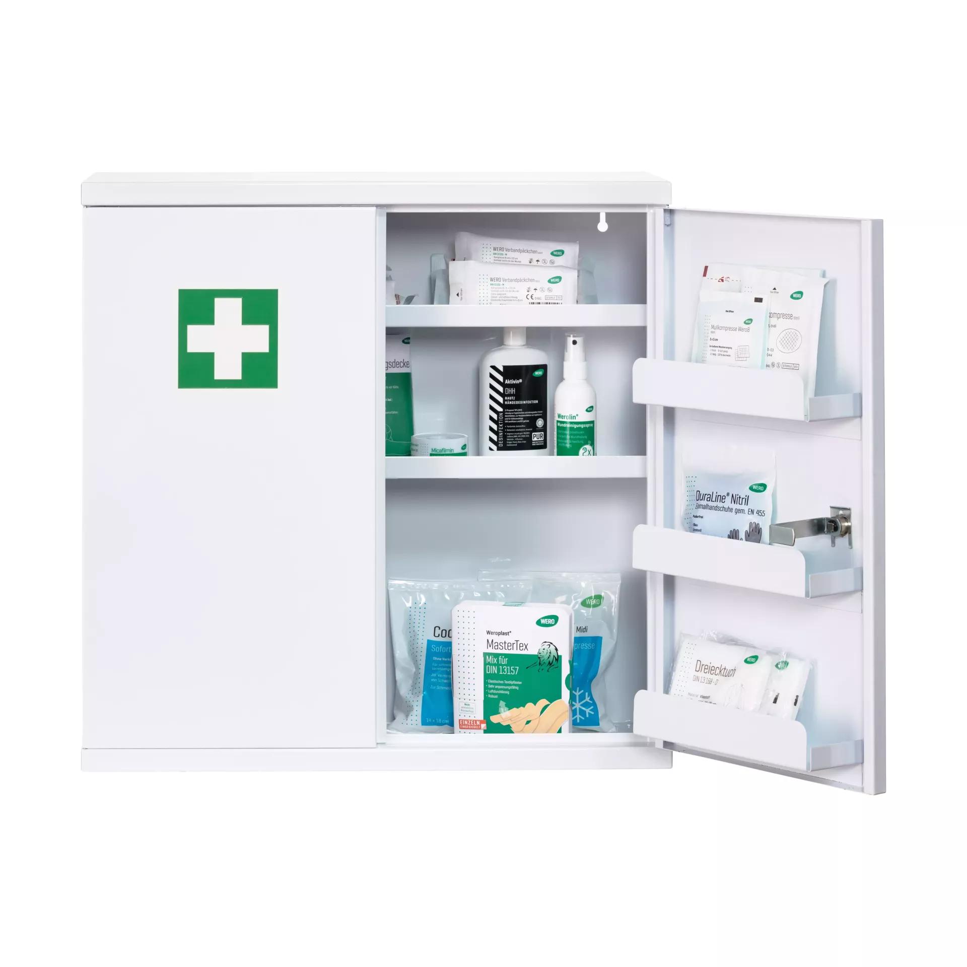 Weißer Erste-Hilfe-Schrank mit zwei Türen und grünem Kreuz, innen bestückt mit Verbandsmaterial und weiteren medizinischen Utensilien.