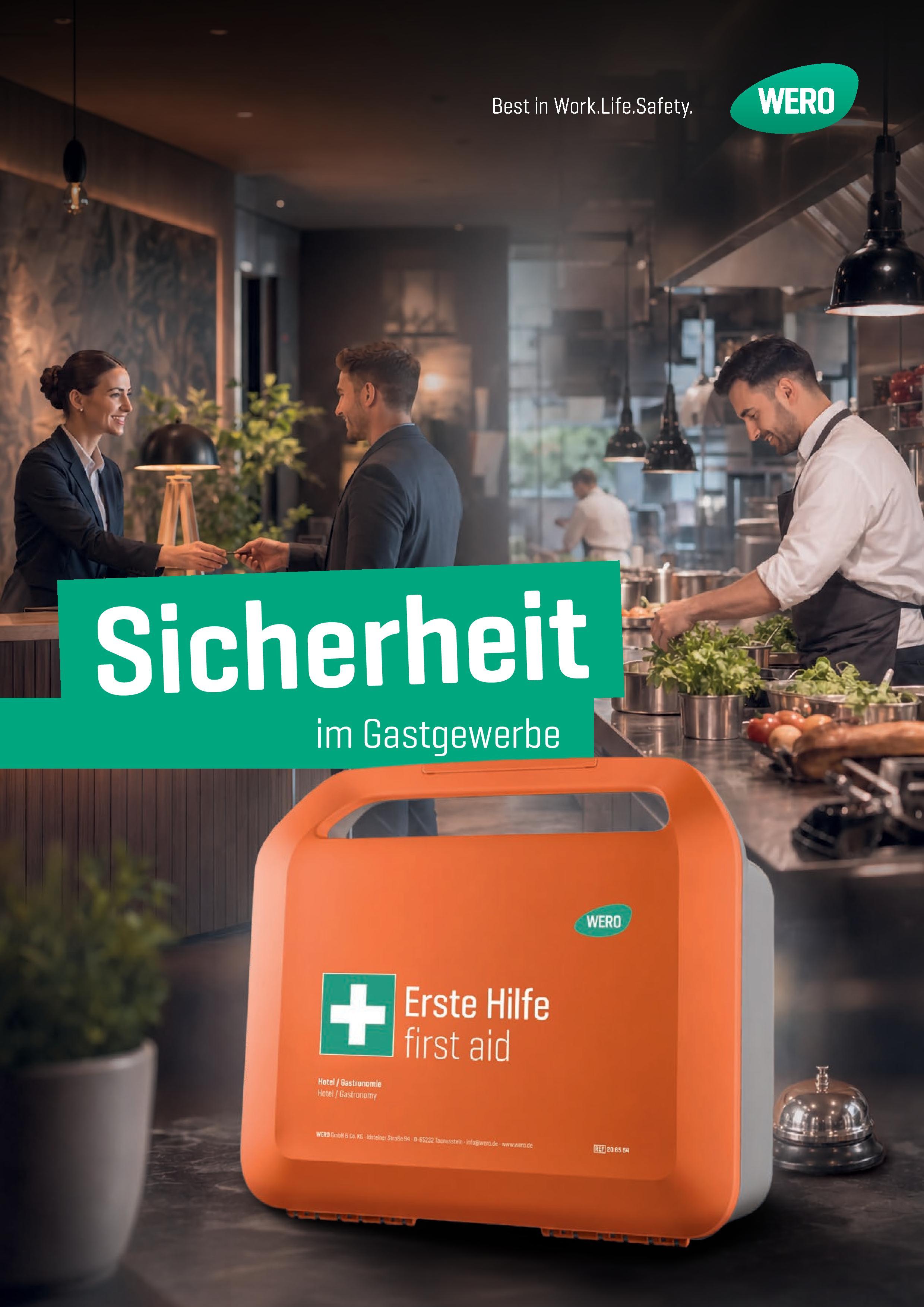 Orange Erste-Hilfe-Box mit weißem Kreuz und Aufschrift „Erste Hilfe first aid“, im Küchenumfeld auf dunkler Arbeitsfläche platziert.