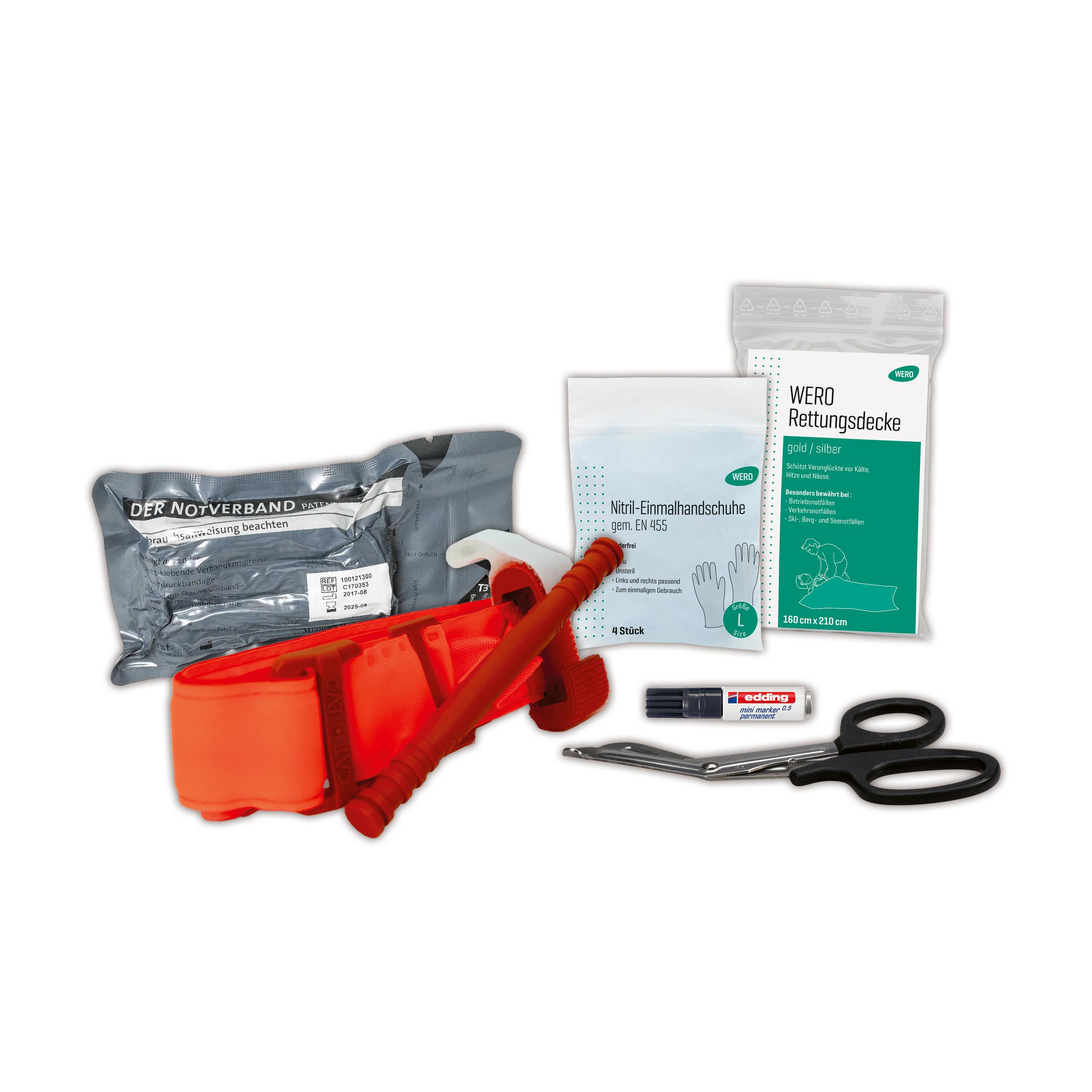 Mehrere medizinische Hilfsmittel wie Schere, Tourniquet, Rettungsdecke und Einmalhandschuhe aus dem WERO Trauma Kit ordentlich nebeneinander platziert.
