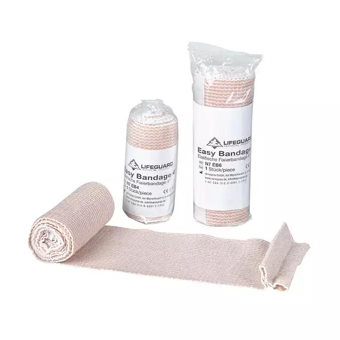 Drei beige, texturierte Lifeguard Easy Bandage - 10 cm Rollen mit sichtbaren Klettstreifen liegen in einer transparenten Plastiktüte.