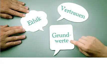 Drei weiße Sprechblasen mit den Wörtern Ethik, Vertrauen und Grundwerte, auf die jeweils Zeigefinger zeigen.