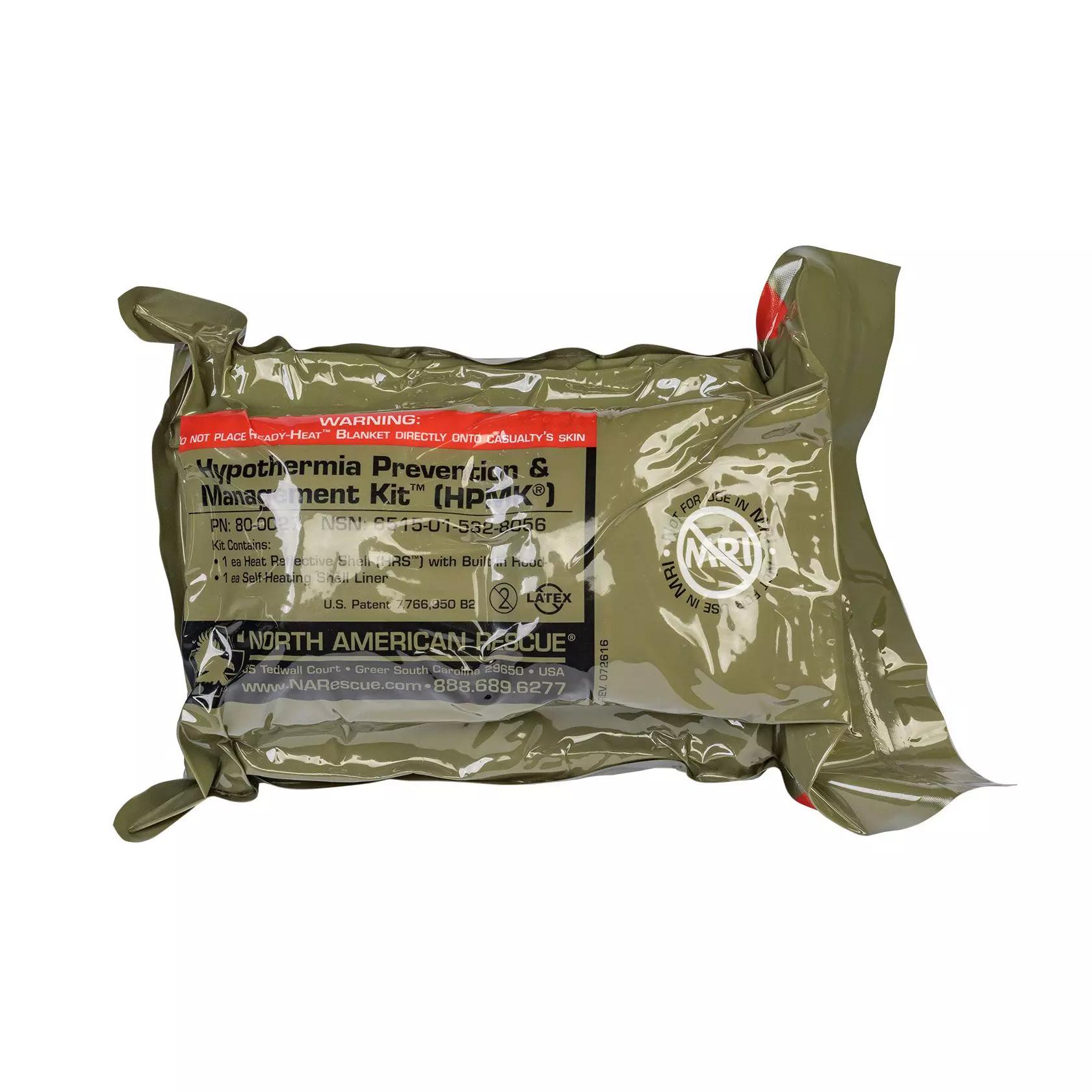 Ein versiegeltes NAR Hypothermia Prevention and Management Kit (HPMK®) im olivgrünen Beutel mit Warnhinweis und Produktdetails auf schwarzem Etikett.
