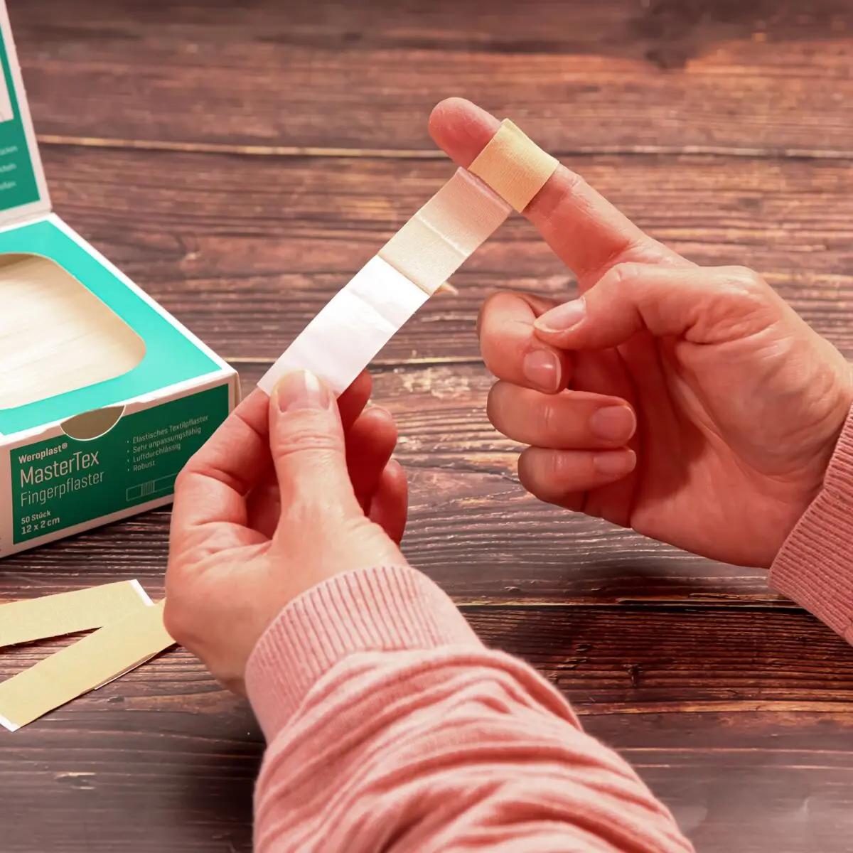 Eine Hand wird mit einem Fingerpflaster Weroplast® MasterTex verbunden, dessen textiles Gewebe besonders anpassungsfähig ist.
