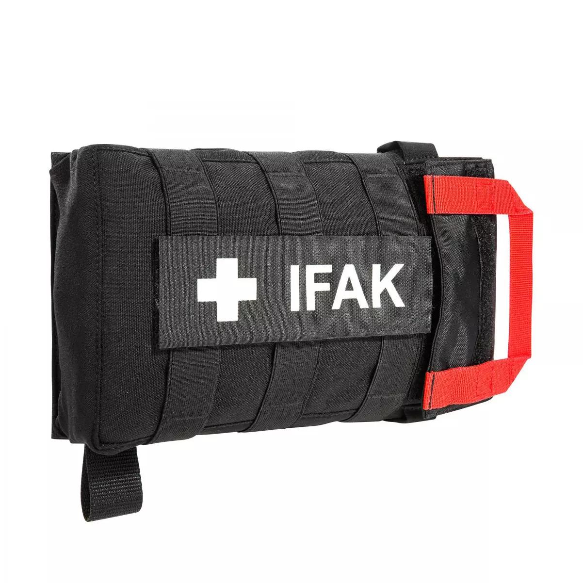 Kompaktes TT IFAK Pouch VL - Schwarz mit weißem Kreuz, roten Tragegriff, gesicherten Riemen und MOLLE-Flauschklett-Adapter auf Vorderseite.