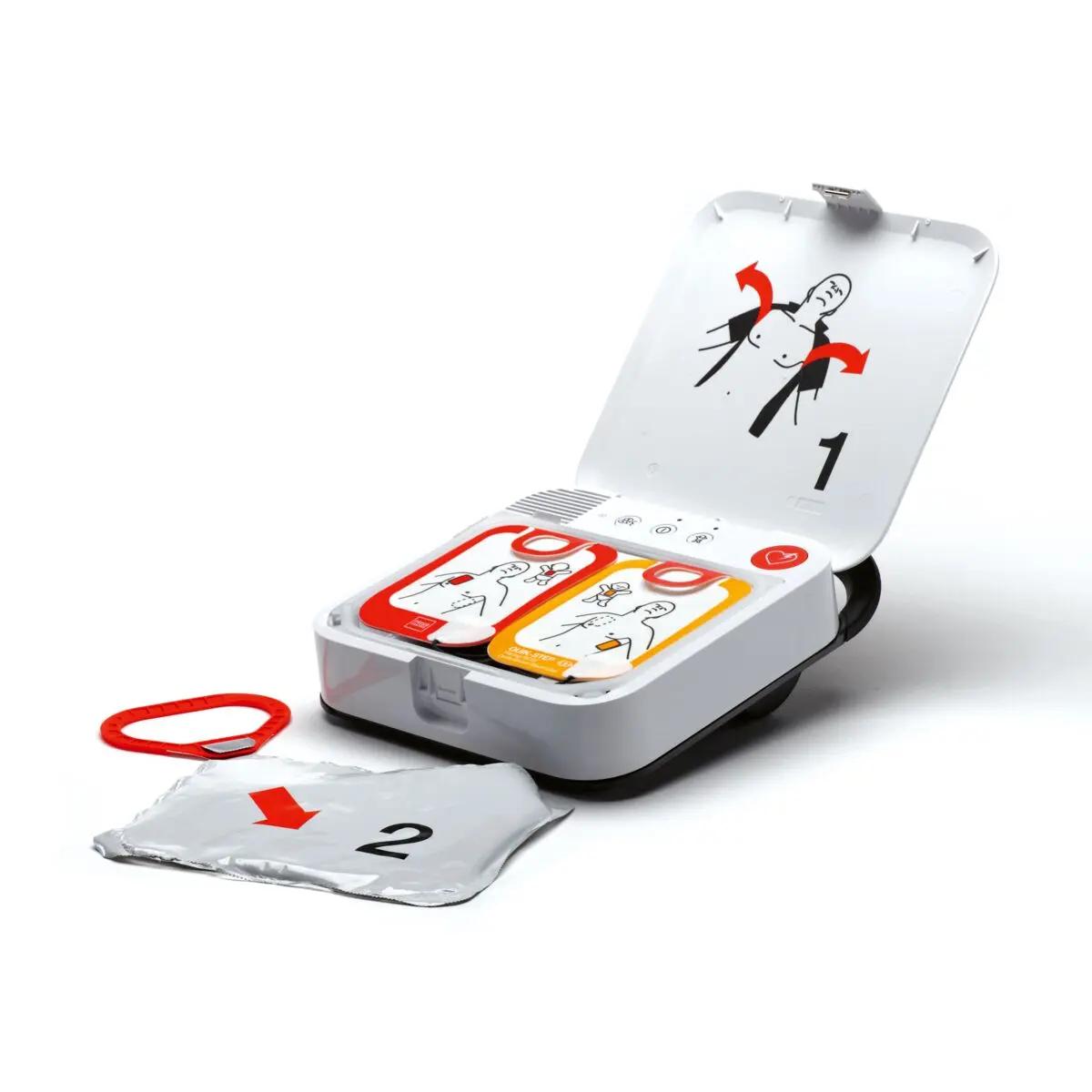 Defibrillator-Set LIFEPAK CR2 mit Griff - Halbautomat, 4G geöffnet mit zwei farbigen Kompakten, sichtbarem Griff, rotem Herztaster und silbernem Elektrodenbeutel.