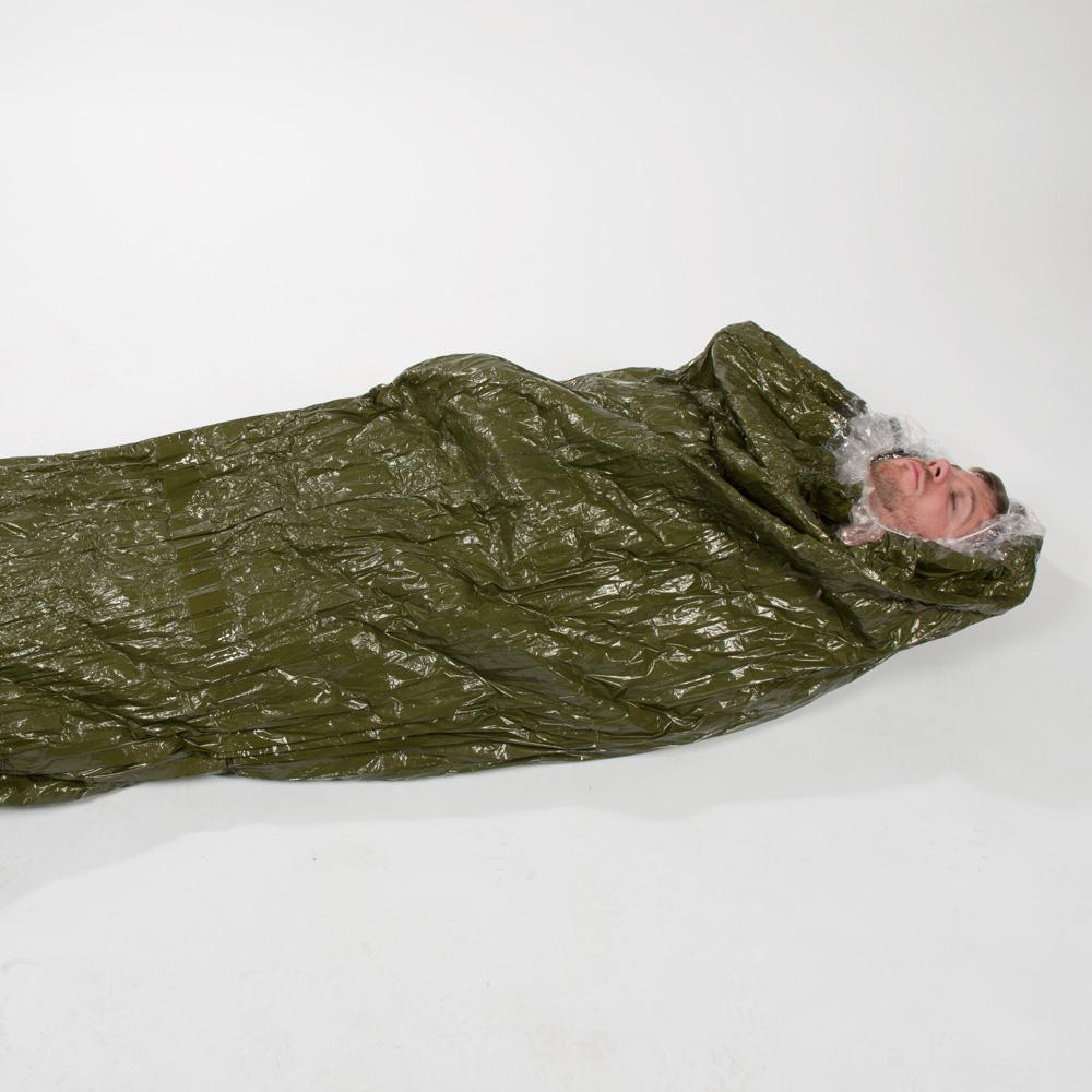 Ein Mann liegt in einem Blizzard - Grün, Schlafsack mit Blizzard Reflexcell™ Technologie, der für optimale Wärmeisolierung und Schockversorgung konzipiert ist.