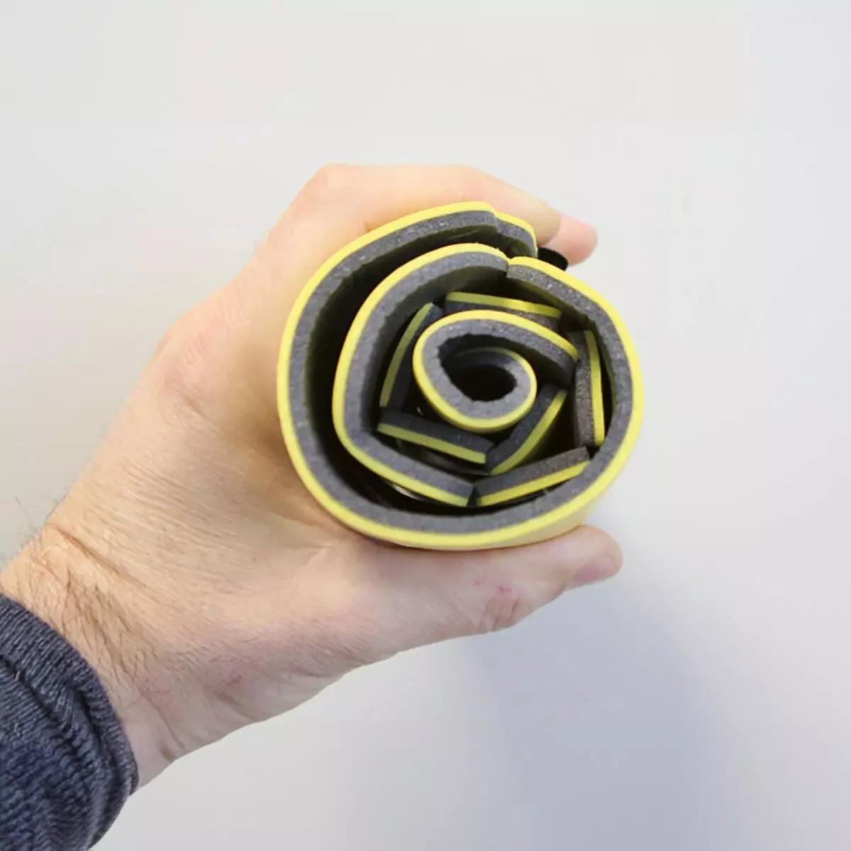 Eine Hand hält den flexiblen Immobilisationskragen Necklite™ - Gelb aus Aluminium-Schaumstoff-Verbund mit strukturierter Oberfläche aufgespannt.