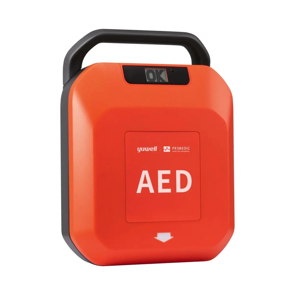 Defibrillator-Set HeartSave Y/YA in Orange mit schwarzem Griff, Displayanzeige „OK“ und weißem AED-Schriftzug auf rotem Frontpanel sichtbar.