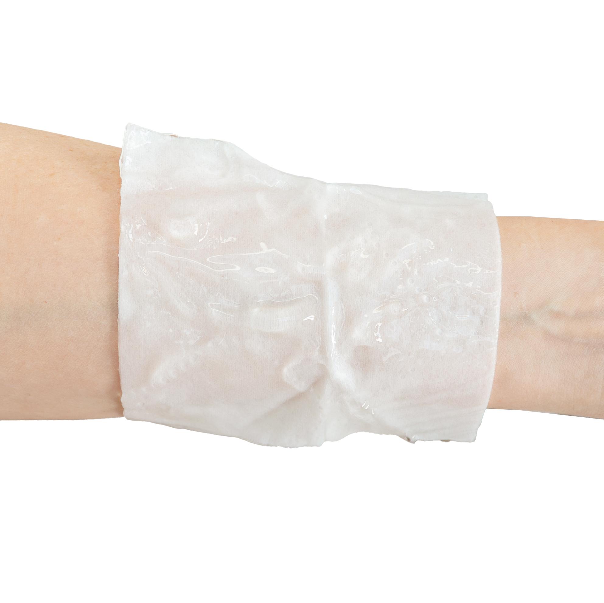 WERO BurnAway® Verbrennungskompresse in 10 x 10 cm Größe flexibel um einen Unterarm gewickelt, mit sichtbaren Falten und glatter Oberfläche.