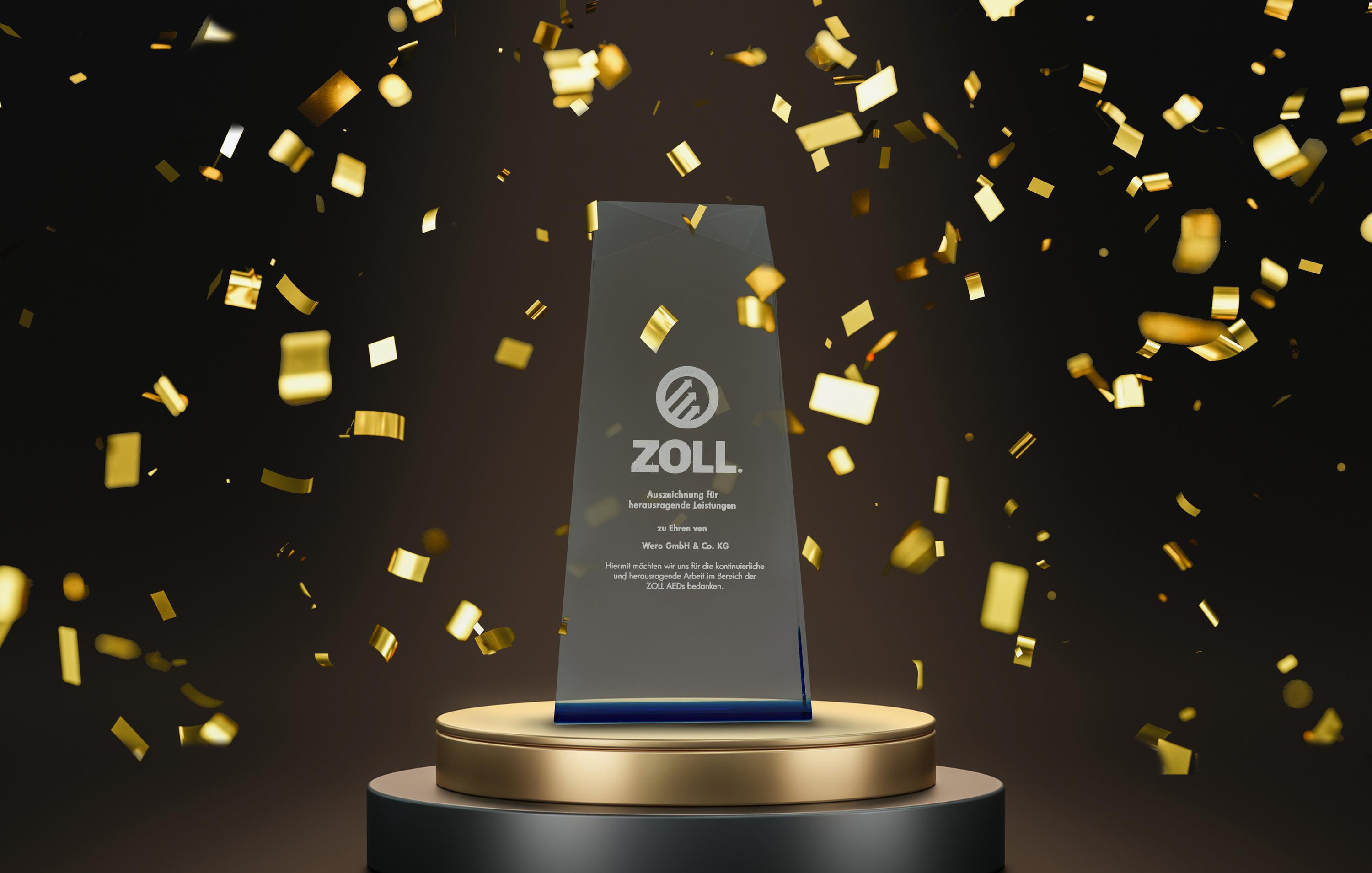 Rechteckiger Glas-Award mit goldener ZOLL-Logo-Gravur auf dunkelblauem Sockel, präsentiert auf goldener Plinthe vor goldenem Konfetti.