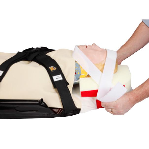 Das CM Trauma Mattress™ Cover mit T-Fix™ ist an einem Trainingsdummy angebracht, mit weiß-schwarzen Kopffixierungsriemen und schwarzer Rückengurtung.