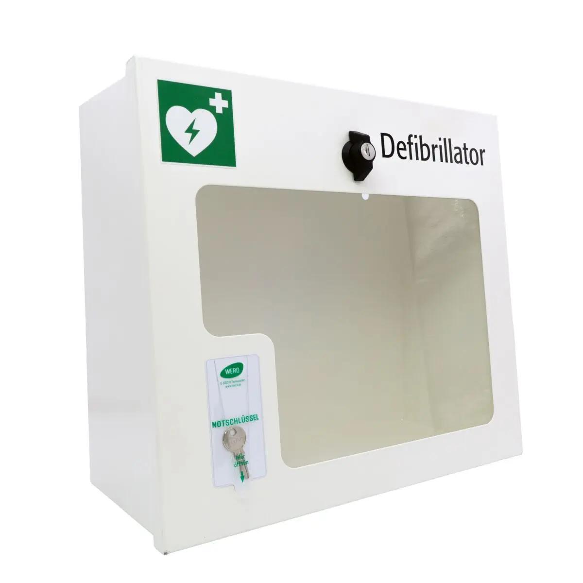 Weißer AED-Wandschrank (gebraucht) mit grünem Herzsymbol, Sichtfenster, abschließbarem Drehverschluss und Alarmfunktion auf der Vorderseite.