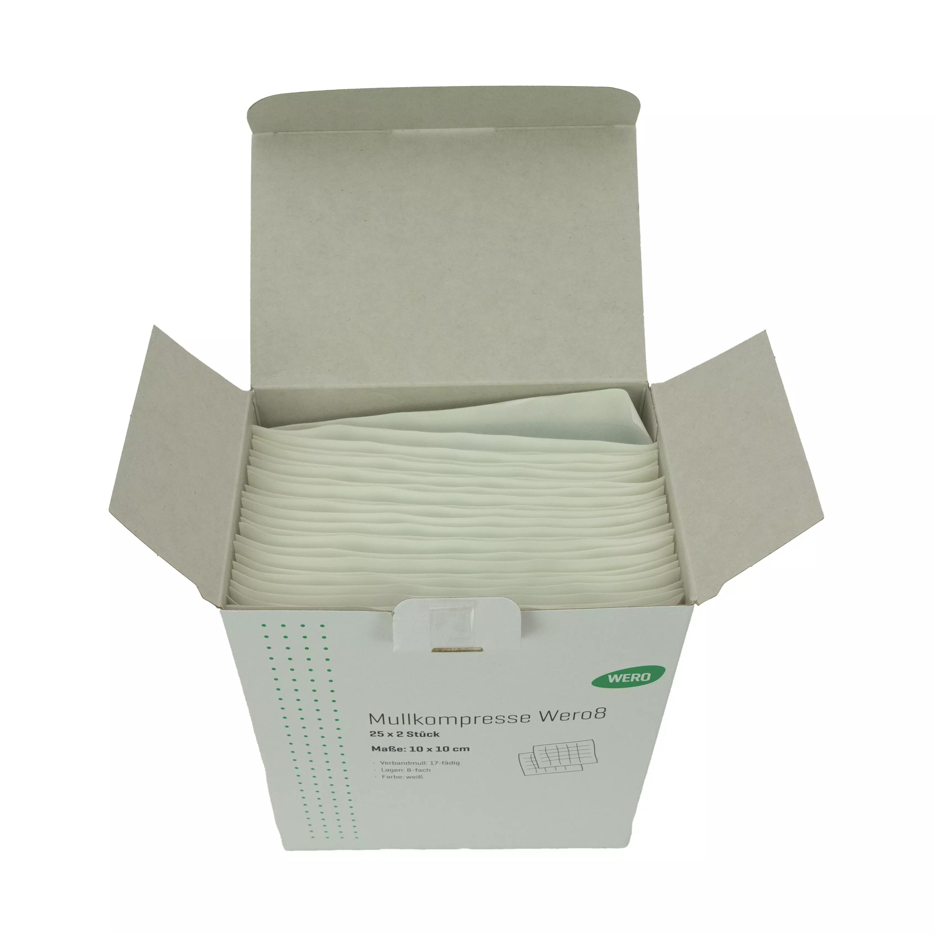 Eine aufrecht stehende Box Mullkompresse Wero8, 10 x 10 cm, steril - 25 x 2 Stk zeigt durch die offene Oberseite gestapelte weiße Mullkompressen aus 100 % Baumwolle mit stabilen Kanten.
