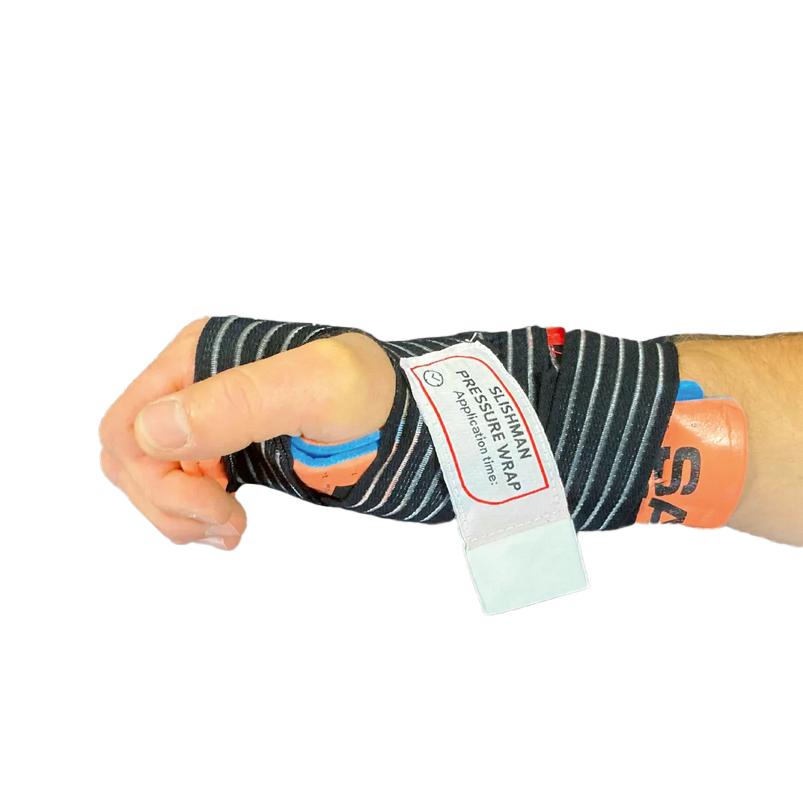 Eine Hand trägt den Slishman Pressure Wrap - Schwarz mit schwarzen und grauen Streifen, orangefarbenem Gurt und weißem Anwendungsetikett am Handgelenk.